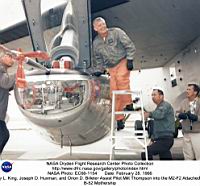 Milt Thompson, toujours aussi enthousiaste à grimper dans une des baignoires volantes (ici un M2F2), accroché au mât d’aile d’un B52F. Noter l’excellente visibilité vers l’avant, et la forme ramassée du véhicule.